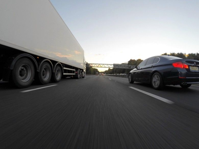 semi truck and passenger car driving on a highway